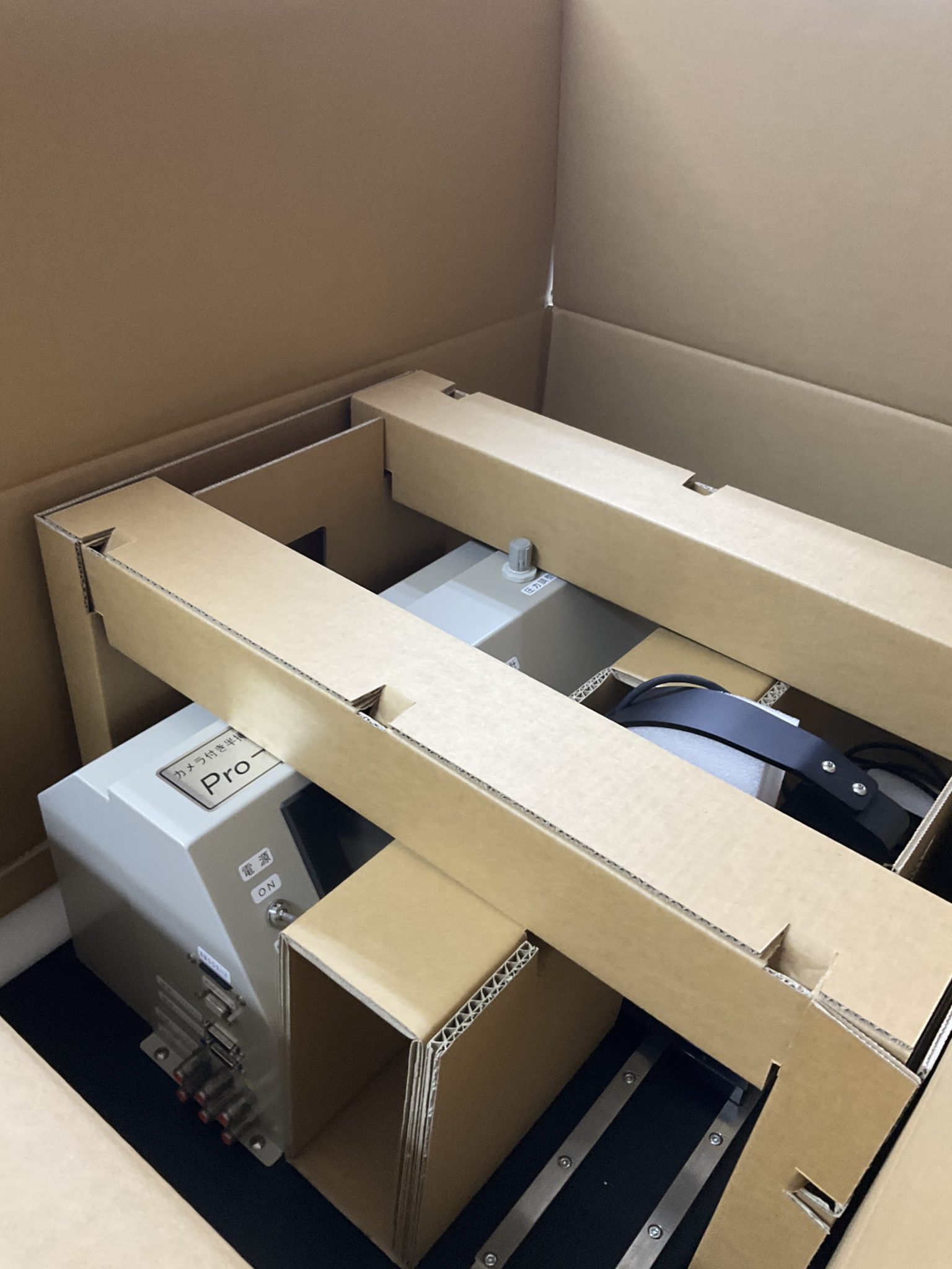 「保護中: 底面緩衝+段ボール抑えで精密機器を安全・低コストに輸送!」の画像